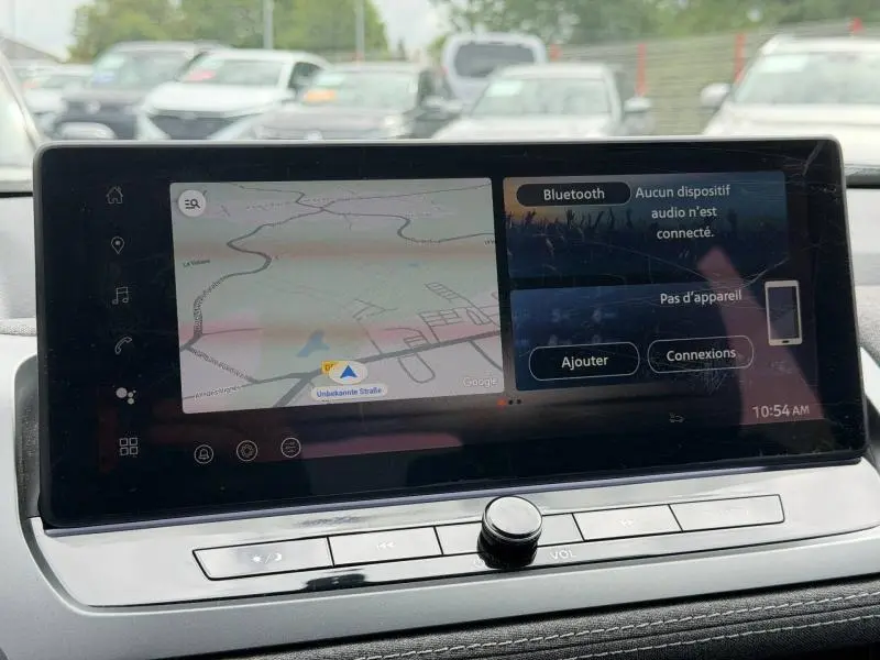 Écran tactile central du Nissan Qashqai 2025 affichant la navigation et les options Bluetooth, vue intérieure frontale.