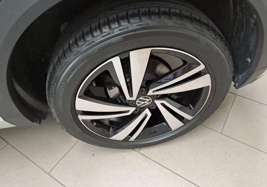 Gros plan sur la jante alliage bicolore du Volkswagen T-Roc 1.5 TSI 150 DSG7 R-Line gris Ascot, côté avant droit.