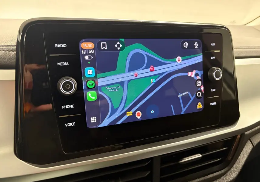 Écran tactile central du Volkswagen T-Roc 2024 affichant la navigation avec carte et commandes multimédia autour.