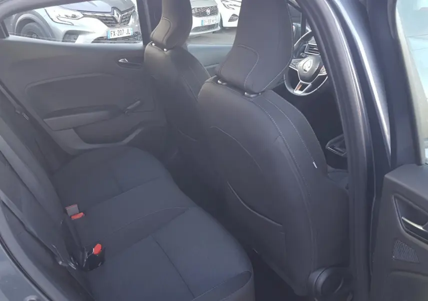 Vue intérieure côté gauche montrant les sièges arrière noirs et l'avant d'une Renault Clio gris 2021.