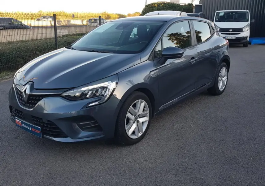 Renault Clio gris 2021 vue 3/4 avant droit, avec phares LED allumés et jantes alliage cinq branches.