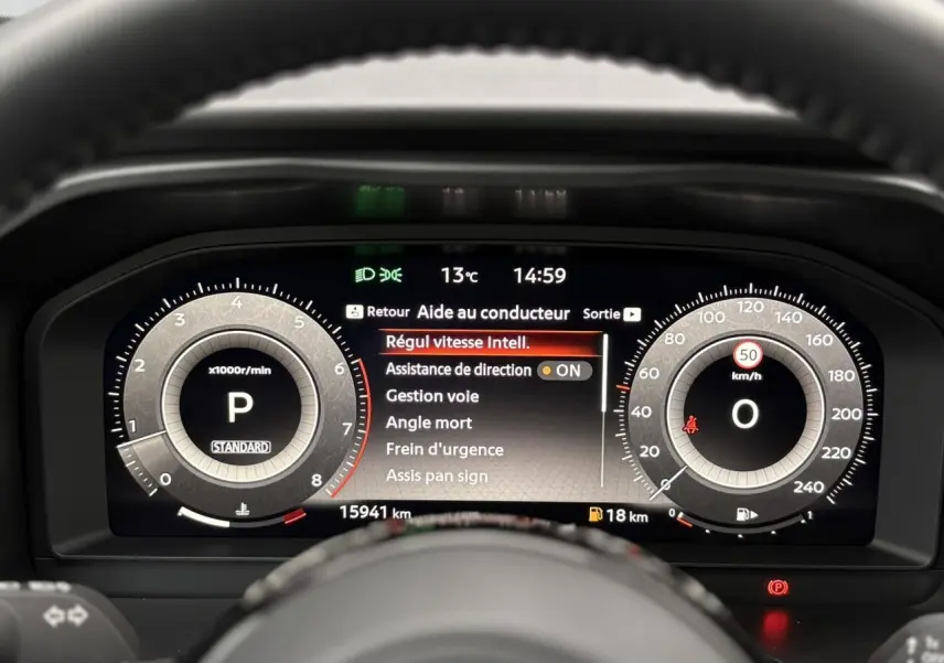 Vue rapprochée du combiné d'instrumentation numérique du Nissan Qashqai 2024 affichant les aides à la conduite et la vitesse à 0 km/h.