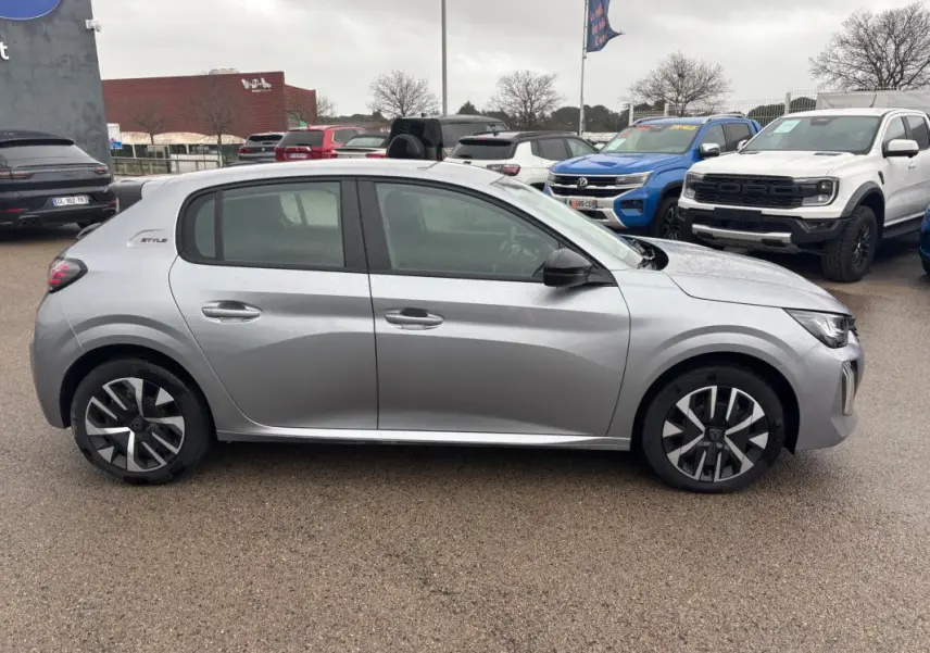 Peugeot 208 Hybrid gris vue de profil côté gauche, avec jantes 16 pouces et badge Style visible à l'arrière.