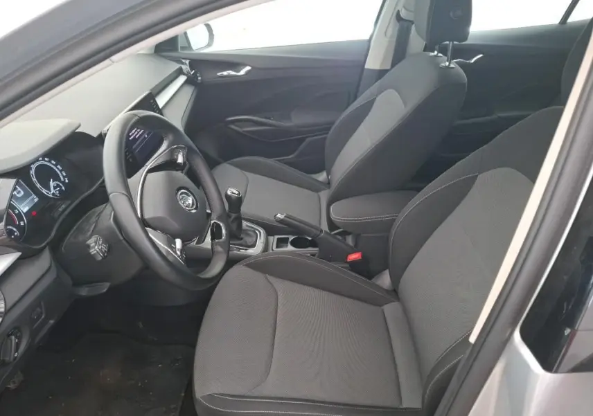 Vue intérieure côté conducteur de la Skoda Fabia Ambition 2023, sièges gris et volant avec boîte manuelle.