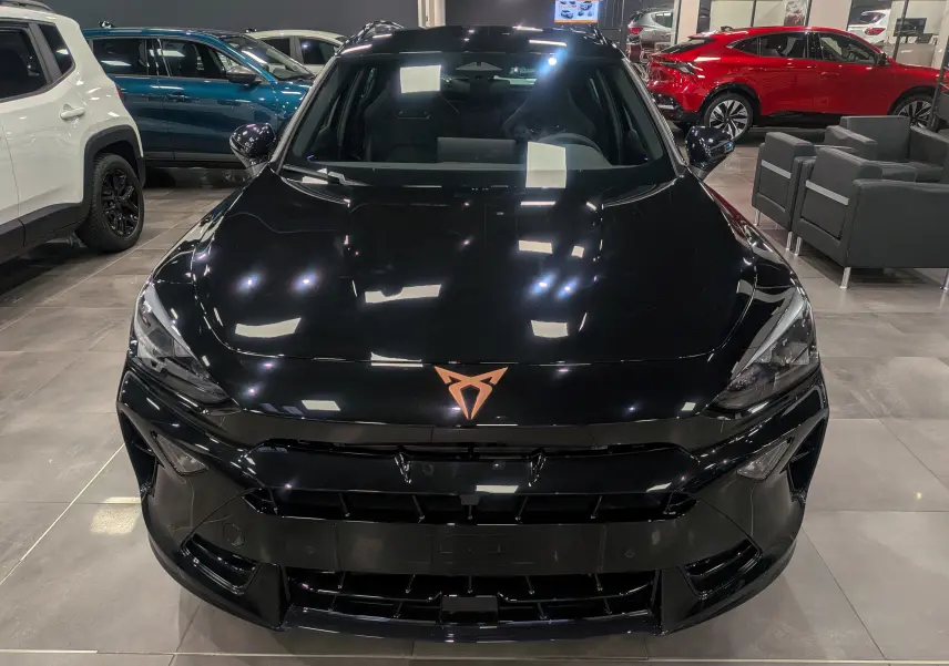 Vue avant d’une CUPRA Formentor eHybrid 2025 en noir minuit, avec logo cuivre distinctif sur le capot lisse.