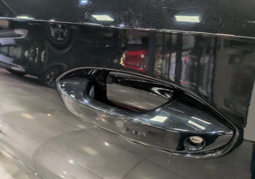 Poignée de porte noire Minuit en gros plan sur une CUPRA Formentor eHybrid 2025, reflet brillant sur la carrosserie.