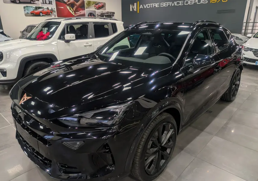 Vue 3/4 avant d'un CUPRA Formentor eHybrid 204 CH noir minuit, avec jantes noires et intérieur visible à travers les vitres teintées.