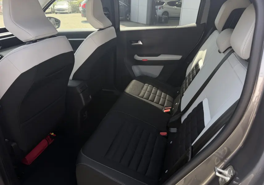Banquette arrière bicolore beige et noir du Citroën C3 Aircross électrique 2025, vue intérieure depuis l'avant.