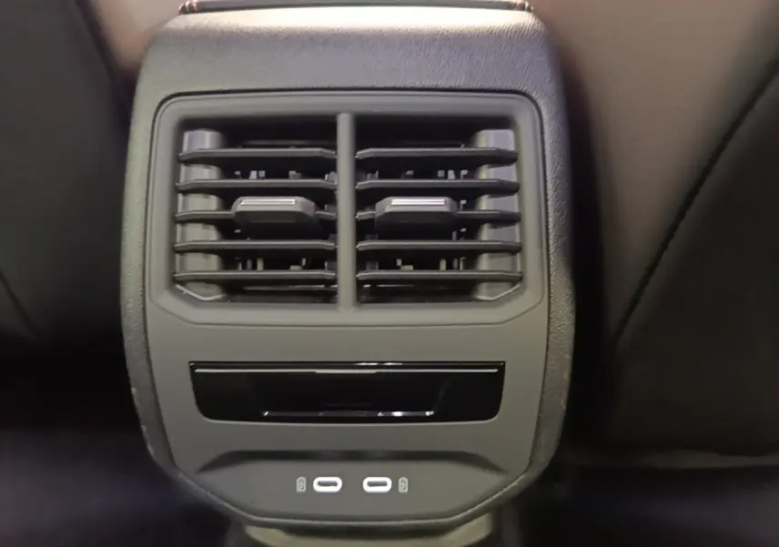 Gros plan sur la console centrale arrière noire du CUPRA Formentor 1.4 e-HYBRID avec bouches d’aération et ports USB.