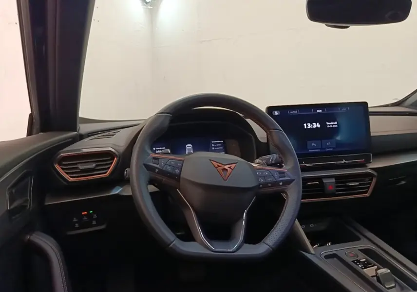 Vue intérieure du tableau de bord et volant noir de la CUPRA Formentor 1.4 e-HYBRID avec écran tactile central.