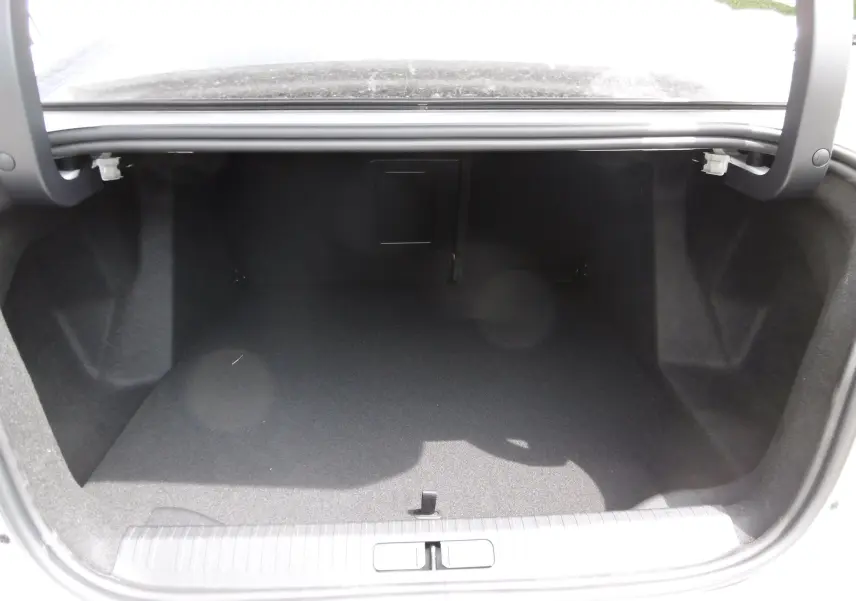 Coffre ouvert vu de l'arrière d'une Citroën C4 X blanc polaire, espace de chargement vide et propre.