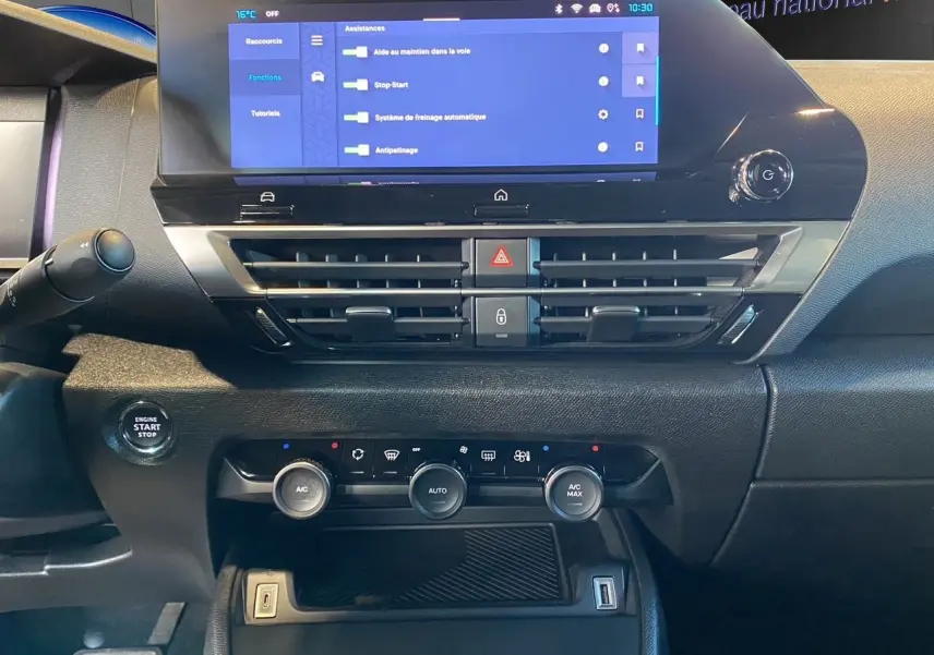 Vue rapprochée du tableau de bord noir perla nera de la Citroën C4 2023 avec écran tactile et commandes climatisation.