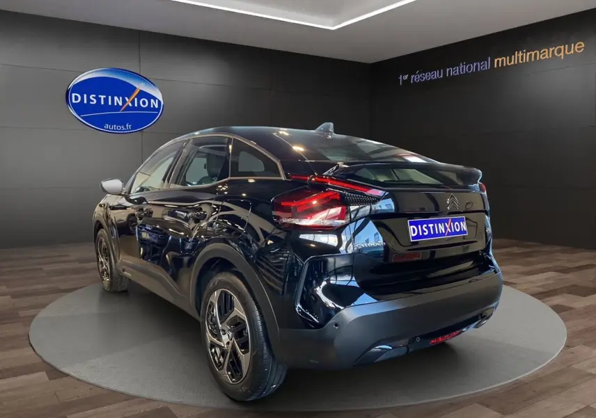 Vue 3/4 arrière droite d'une Citroën C4 noire Perla Nera 2023 avec feux arrière LED et jantes alliage.