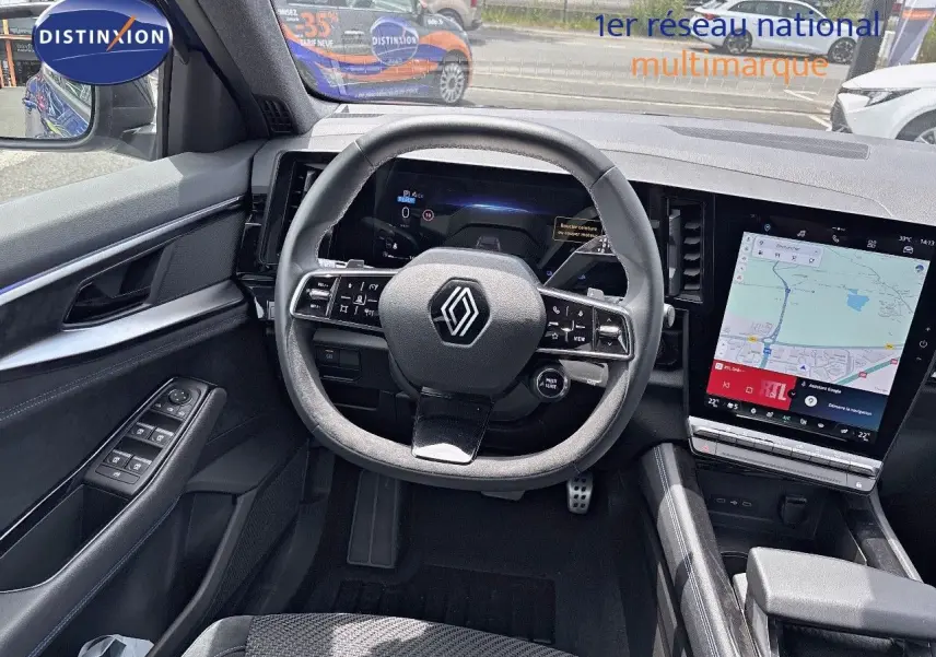 Vue intérieure du tableau de bord du Renault Austral 2024 hybride, avec volant multifonction et écran tactile GPS.