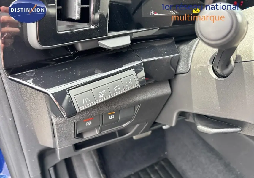 Vue intérieure du tableau de bord côté gauche du Renault Austral bleu iron 2024, avec commandes d'assistance et frein électronique.