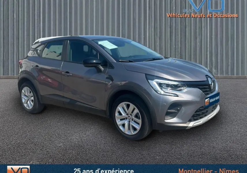 Renault Captur TCe 90 Business gris vu en 3/4 avant droit, avec jantes argentées et calandre noire brillante.
