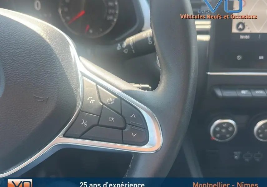 Gros plan sur le volant côté gauche du Renault Captur gris 2022, avec commandes intégrées et tableau de bord en arrière-plan.