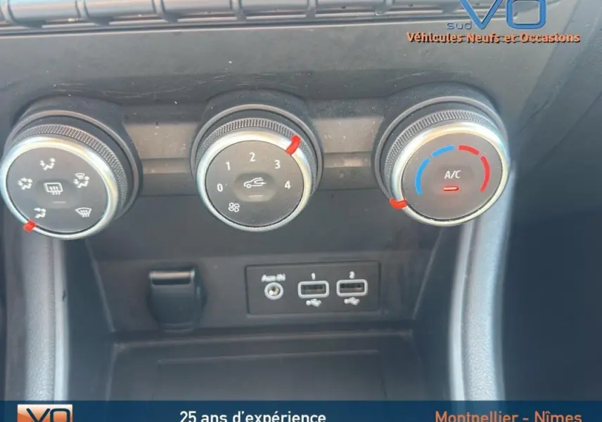 Gros plan sur les commandes de climatisation manuelle et ports USB du Renault Captur gris TCe 90 Business 2022.