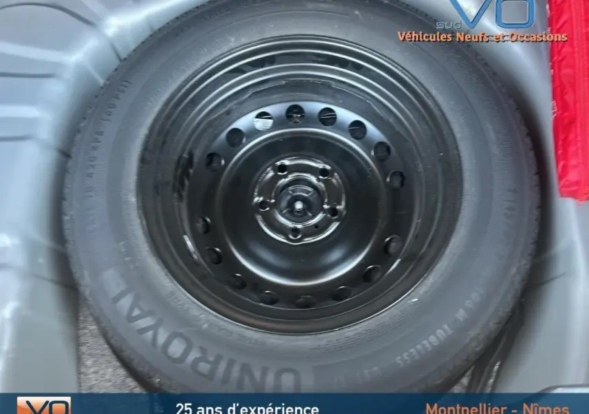 Roue de secours noire en gros plan dans le coffre d'un Renault Captur TCe 90 gris 2022.