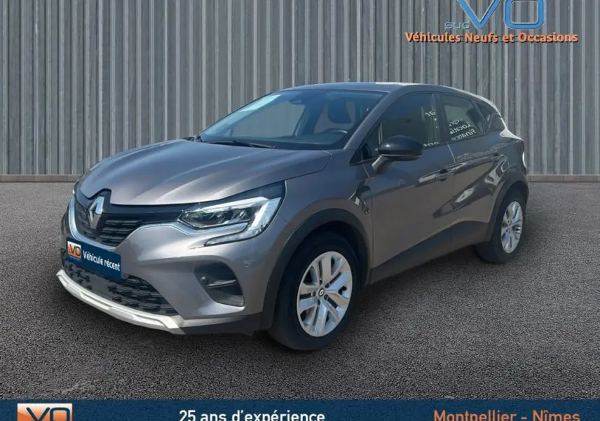 Renault Captur TCe 90 Business gris, vue 3/4 avant droit, avec jantes alliage et calandre noire brillante.