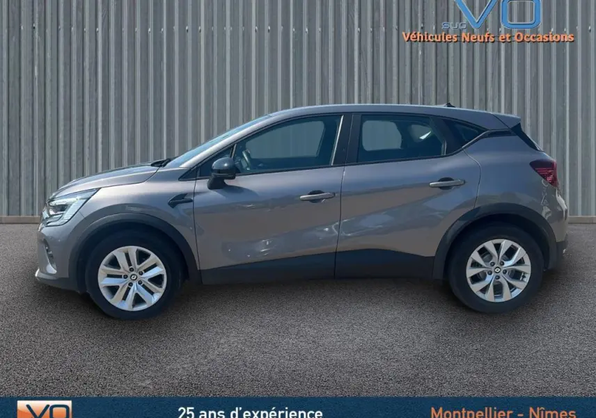 Profil côté gauche d'un Renault Captur gris 2022 TCe 90 Business avec jantes alliage et lignes modernes.