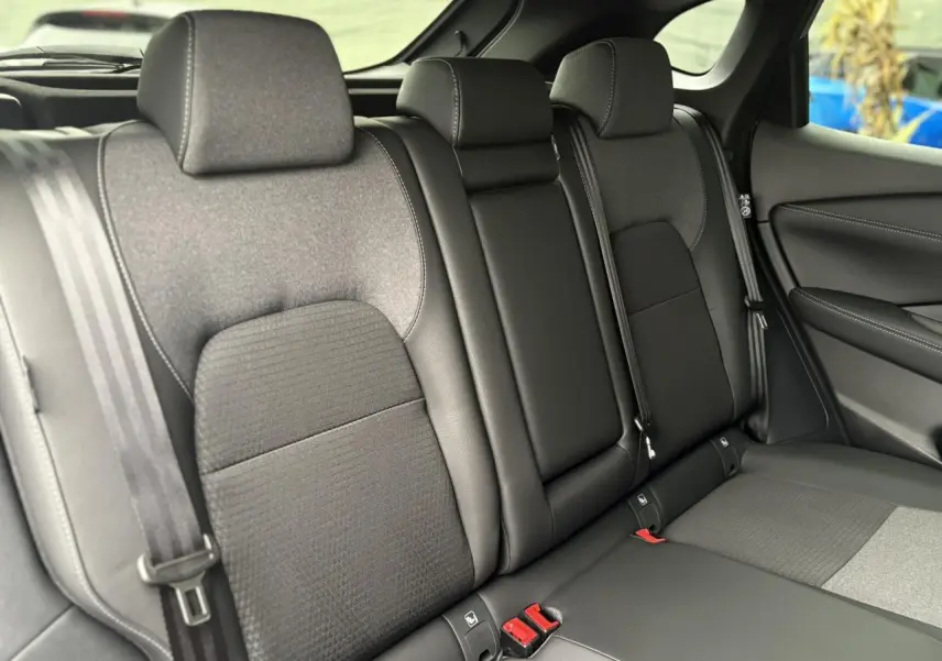 Vue latérale intérieure des sièges arrière noirs du Nissan Qashqai 2024, avec ceintures de sécurité visibles.