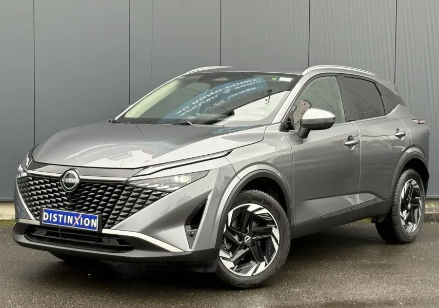 Vue 3/4 avant droite du Nissan Qashqai 2024 gris Squale avec jantes alliage et hayon électrique visible.