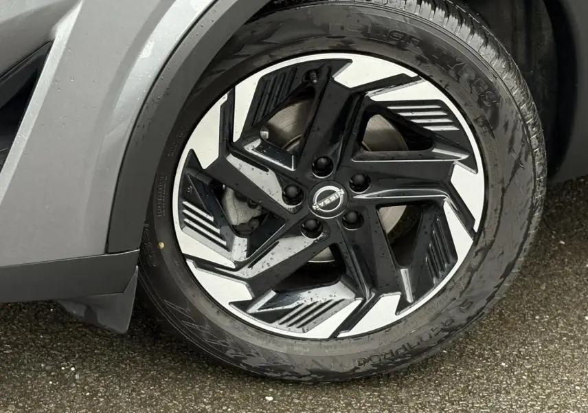 Gros plan sur la jante alliage 18 pouces bicolore noir et argent du Nissan Qashqai gris Squale, côté avant droit.