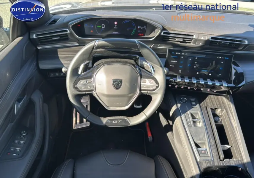 Vue intérieure avant du poste de conduite du Peugeot 508 SW Hybrid gris, avec volant GT et écran tactile large.
