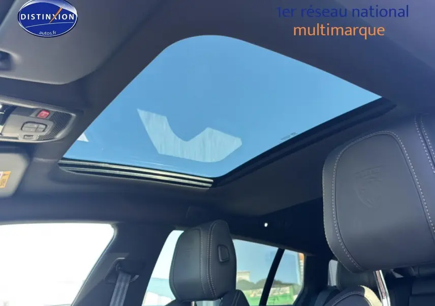 Vue intérieure du toit ouvrant panoramique et des appuis-tête en cuir embossé du Peugeot 508 SW Hybrid 225 gris artense.