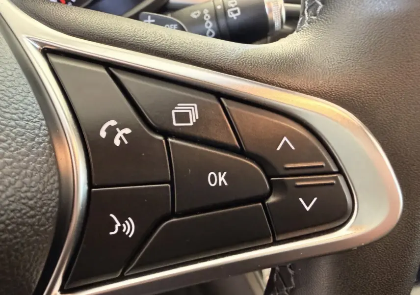 Gros plan sur les commandes noires multifonctions du volant côté droit du Renault Captur blanc, version Business 2021.