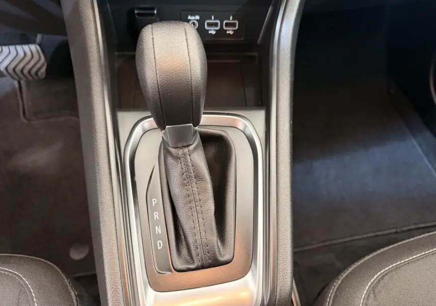 Gros plan sur le levier de vitesses automatique noir du Renault Captur Business blanc, avec ports USB visibles en arrière-plan.
