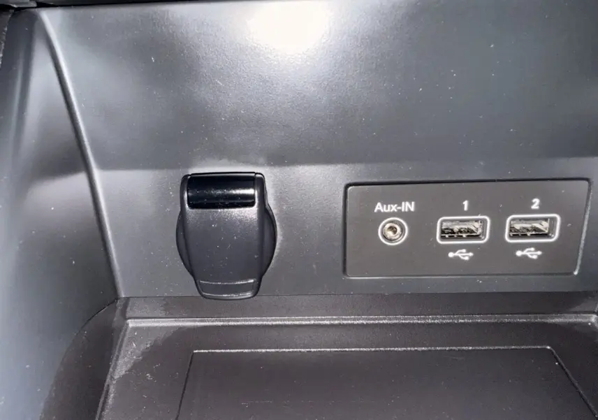 Prise auxiliaire et deux ports USB noirs dans l’habitacle du Renault Captur Business TCe 140 blanc, vue rapprochée.
