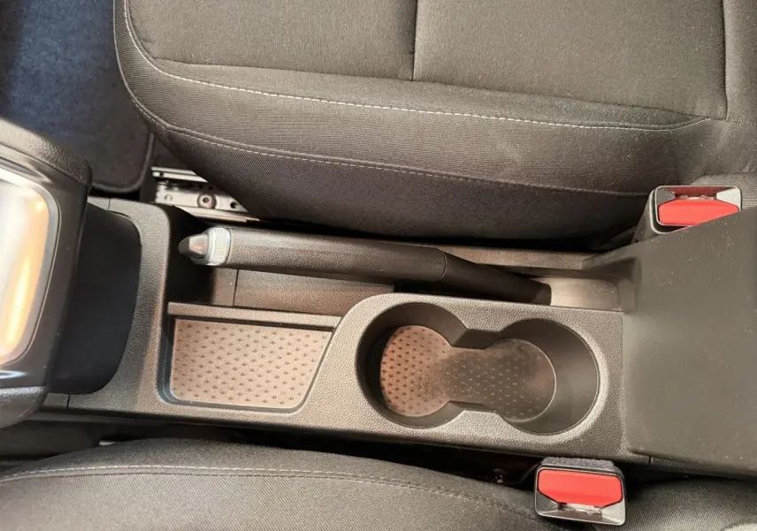 Vue plongeante sur la console centrale noire du Renault Captur 2021 avec frein à main manuel et porte-gobelets.