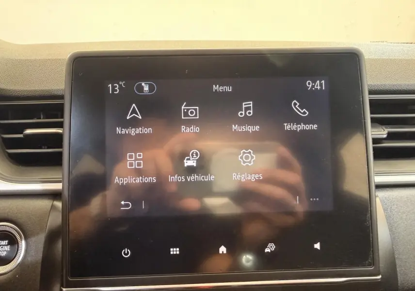 Écran tactile central du tableau de bord du Renault Captur blanc, affichant le menu principal avec options multimédia.