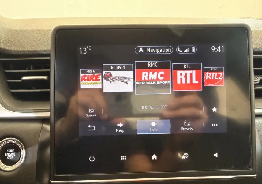 Écran tactile central du tableau de bord du Renault Captur Business blanc, affichant les radios et la navigation.