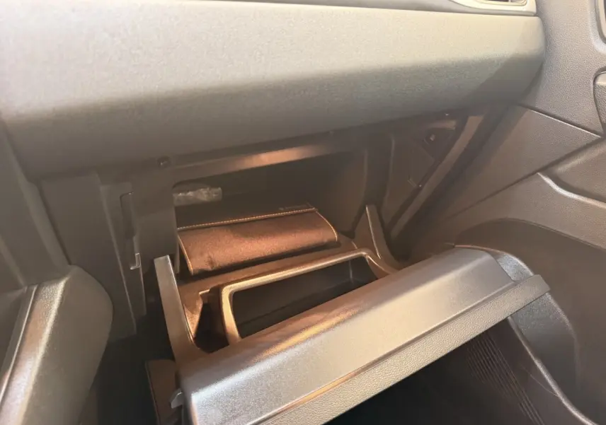 Vue intérieure du coffre à gants ouvert côté passager du Renault Captur blanc, montrant un rangement avec pochette.