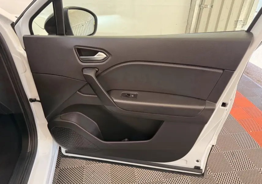 Vue intérieure de la porte avant gauche noire du Renault Captur blanc 2021, avec poignée et commande de vitre visible.