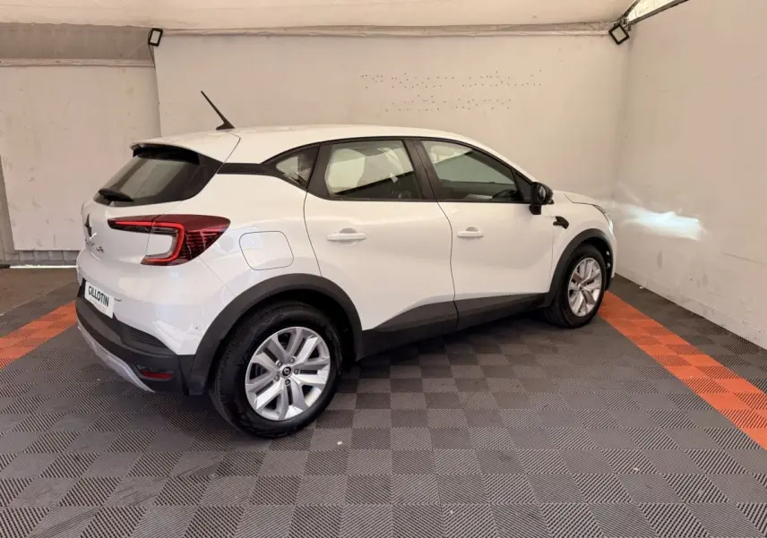 Renault Captur blanc vue 3/4 arrière droit dans un garage avec jantes argentées et feux arrière LED.