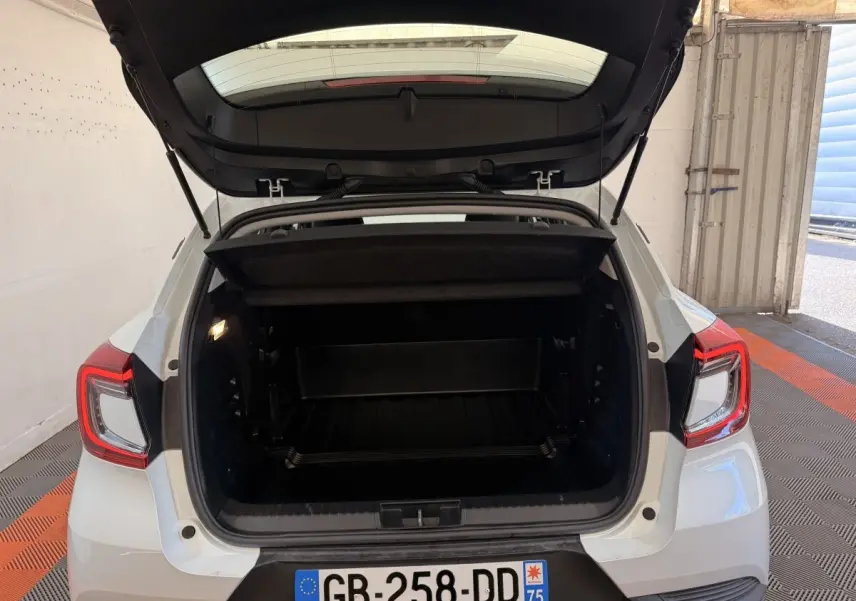 Vue arrière du coffre ouvert d'un Renault Captur blanc 2021, montrant l'espace de chargement intérieur.