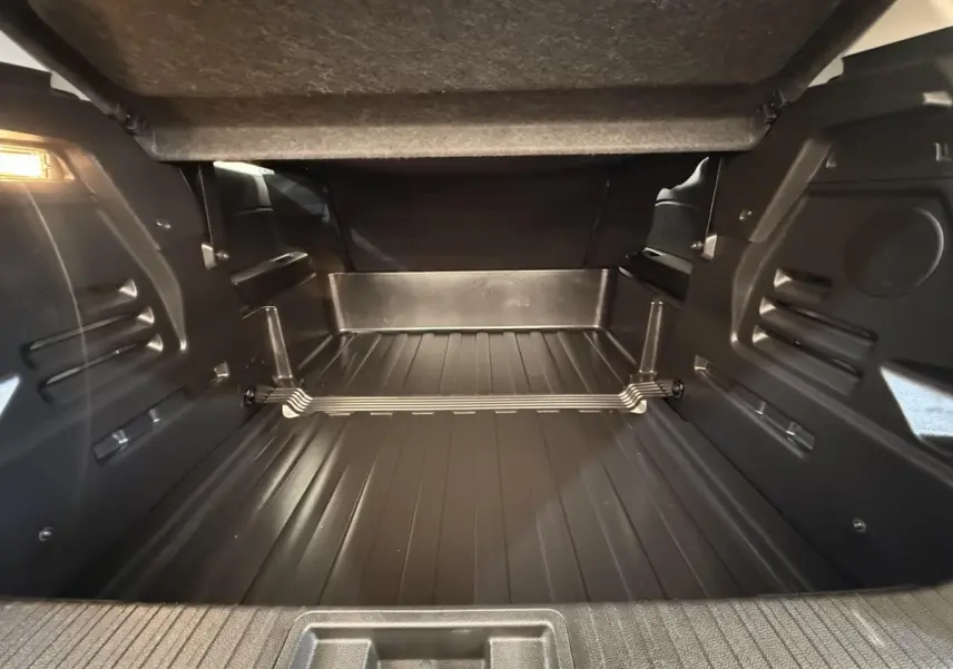 Coffre ouvert du Renault Captur Business blanc, vue intérieure montrant l'espace de chargement et le plancher plat.