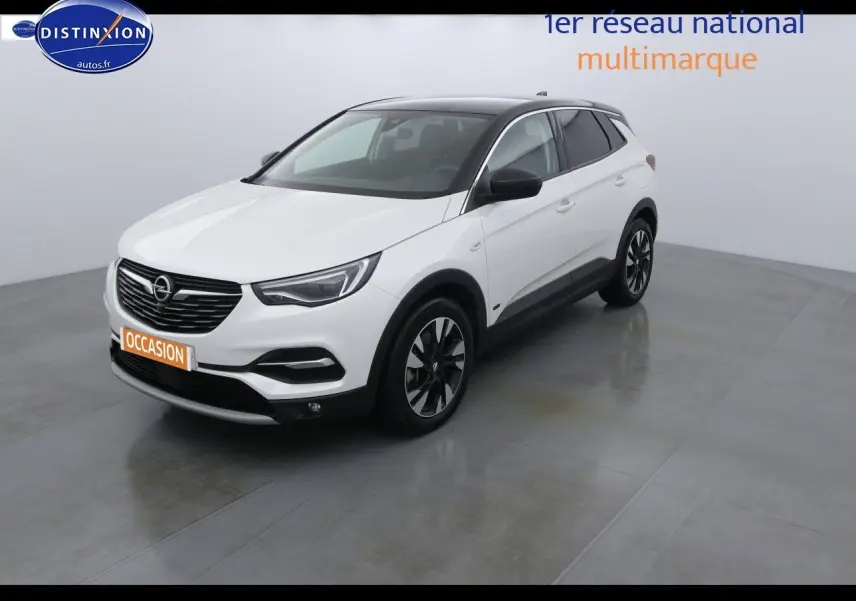 Opel Grandland X blanc nacré vue 3/4 avant droit avec toit noir et jantes alliage bicolores.