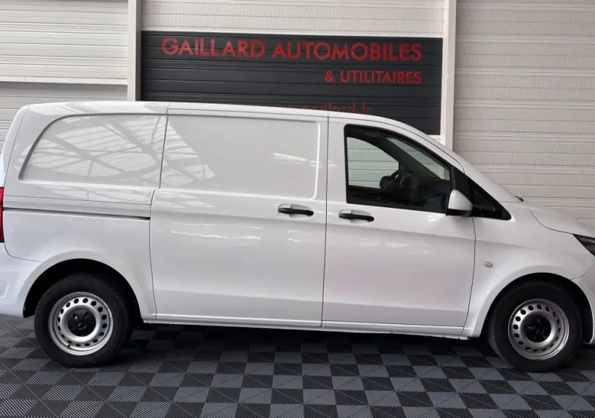 Profil droit d'un utilitaire Mercedes Vito 111 CDI Compact blanc, avec deux portes latérales et hayon arrière fermé.
