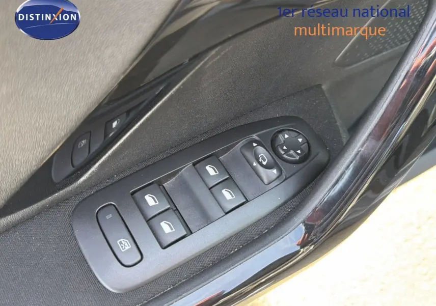 Gros plan sur les commandes des vitres électriques côté gauche d'une Peugeot 2008 gris platinium de 2019.