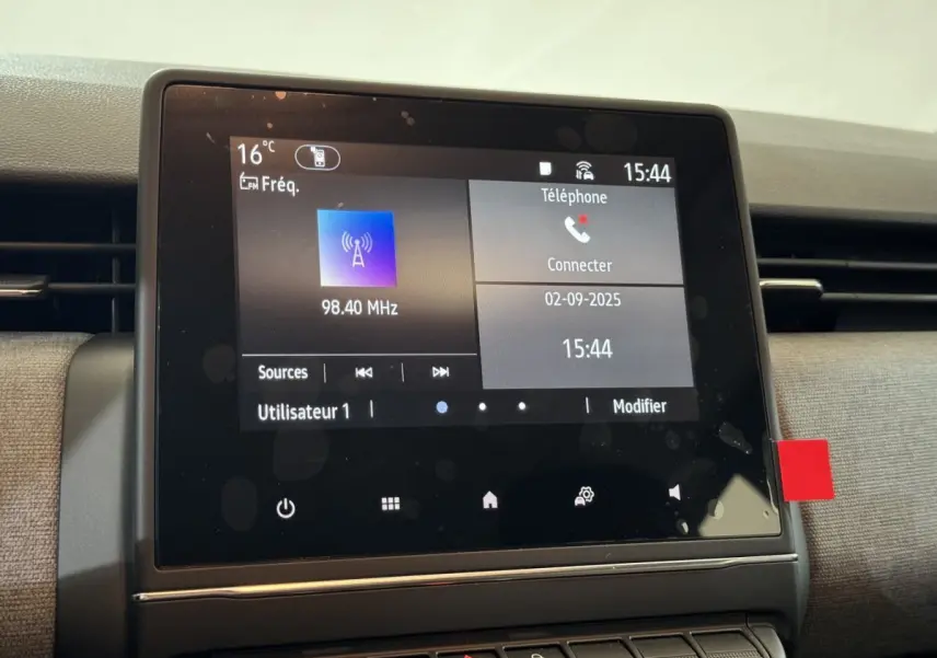 Écran tactile central de 7 pouces affichant la radio et la connexion téléphone dans une Renault Clio gris clair 2025.