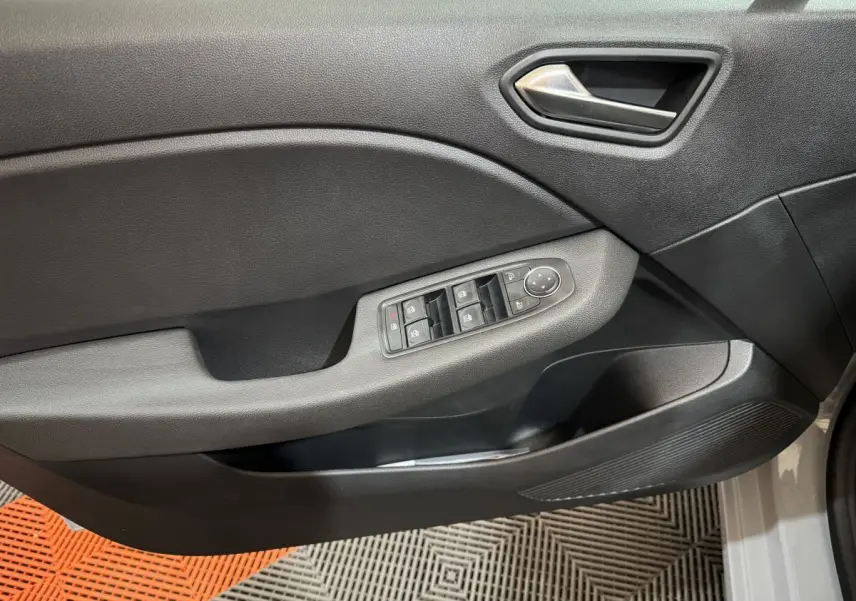 Intérieur côté gauche de la porte d'une Renault Clio gris clair, avec commandes des vitres électriques et poignée argentée.