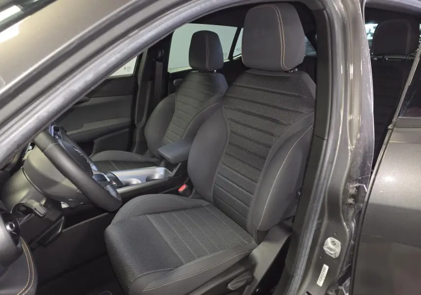 Vue intérieure côté conducteur de l'Alfa Romeo Tonale gris, mettant en valeur les sièges AlfaTec noirs avec surpiqûres beige.