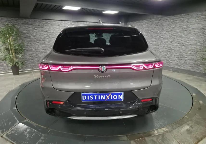 Vue arrière d'une Alfa Romeo Tonale gris métallisé avec feux arrière LED distinctifs et toit noir brillant.