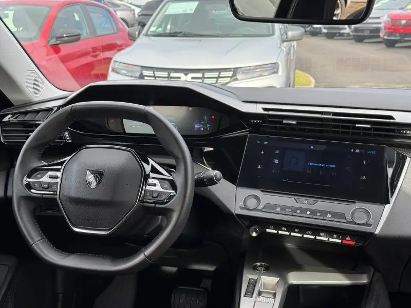 Vue intérieure du tableau de bord et volant de la Peugeot 308 2024 en Noir Perla Nera, avec écran tactile central allumé.
