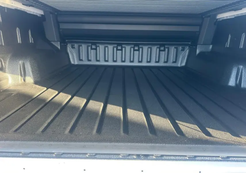 Vue rapprochée de la benne noire du Ford Ranger Raptor blanc 2025, soulignant son espace de chargement robuste.